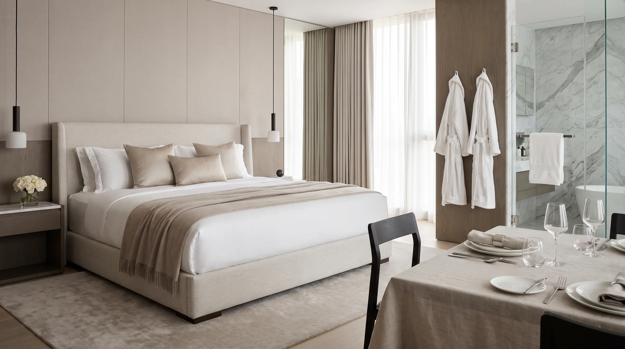 Helle Hotelsuite mit bezogenem Bett, Handtüchern und Bademänteln