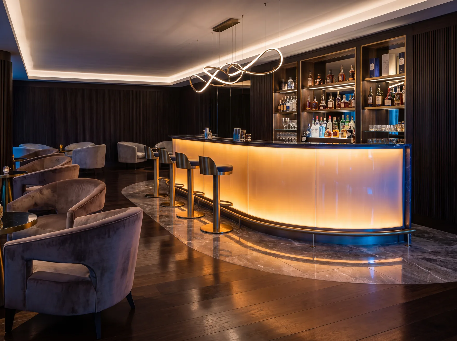 Hotelbar mit geschwungener beleuchteter Front und Barhockern